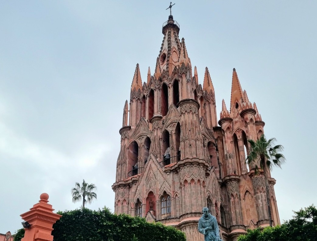 A cobbled San Miguel street runs down toward the town between coloured façades