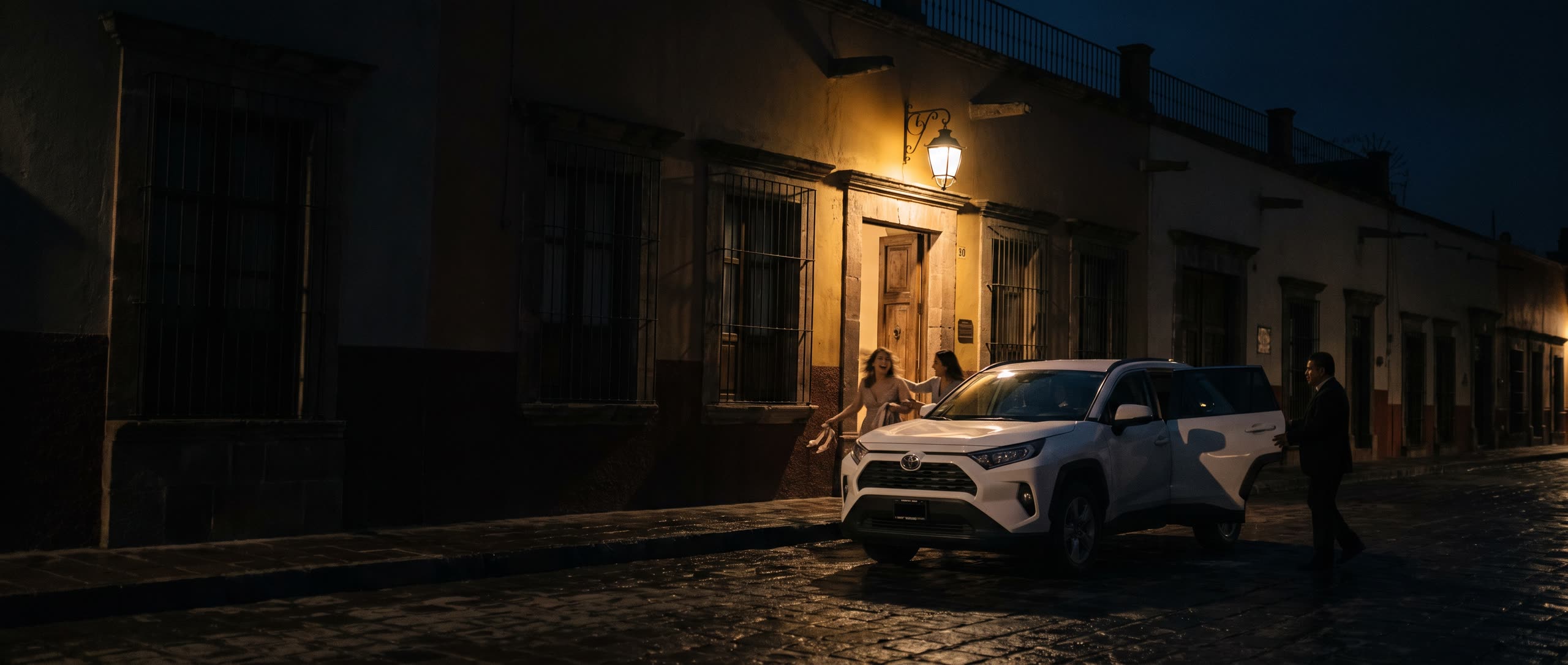 A San Miguel street at night, a white SUV waiting