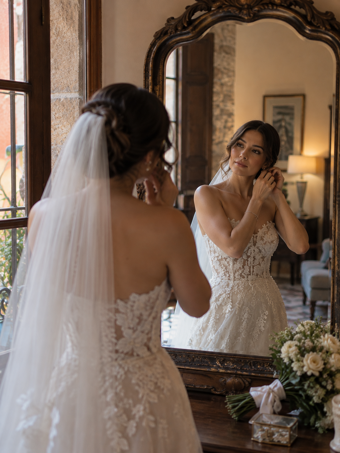 A hand holds the bride’s veil beside a car door